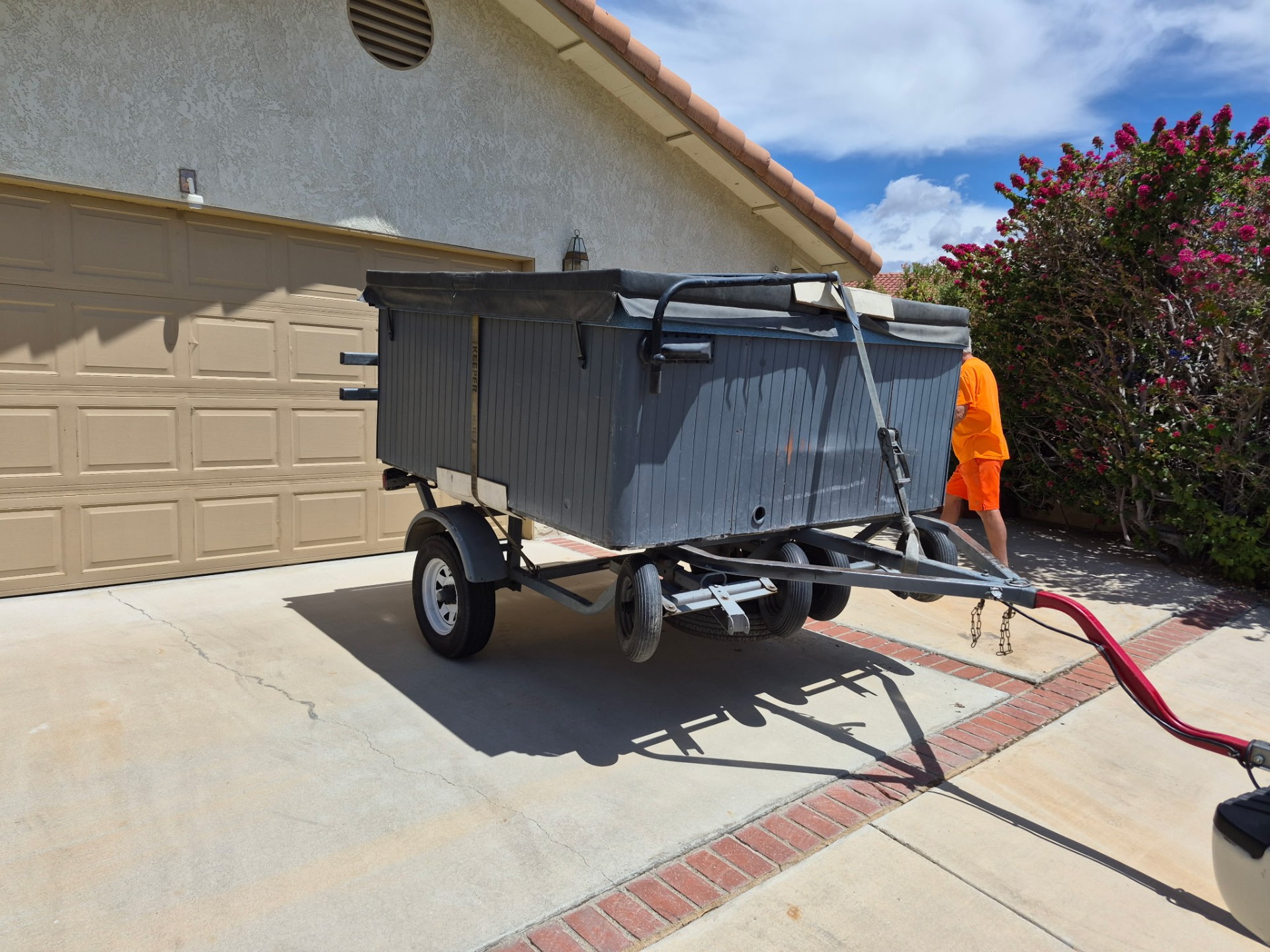 Hot tub strapped to the A&J Spa Pros trailer in a Desert Hot Springs driveway, ready for the Beaumont move
