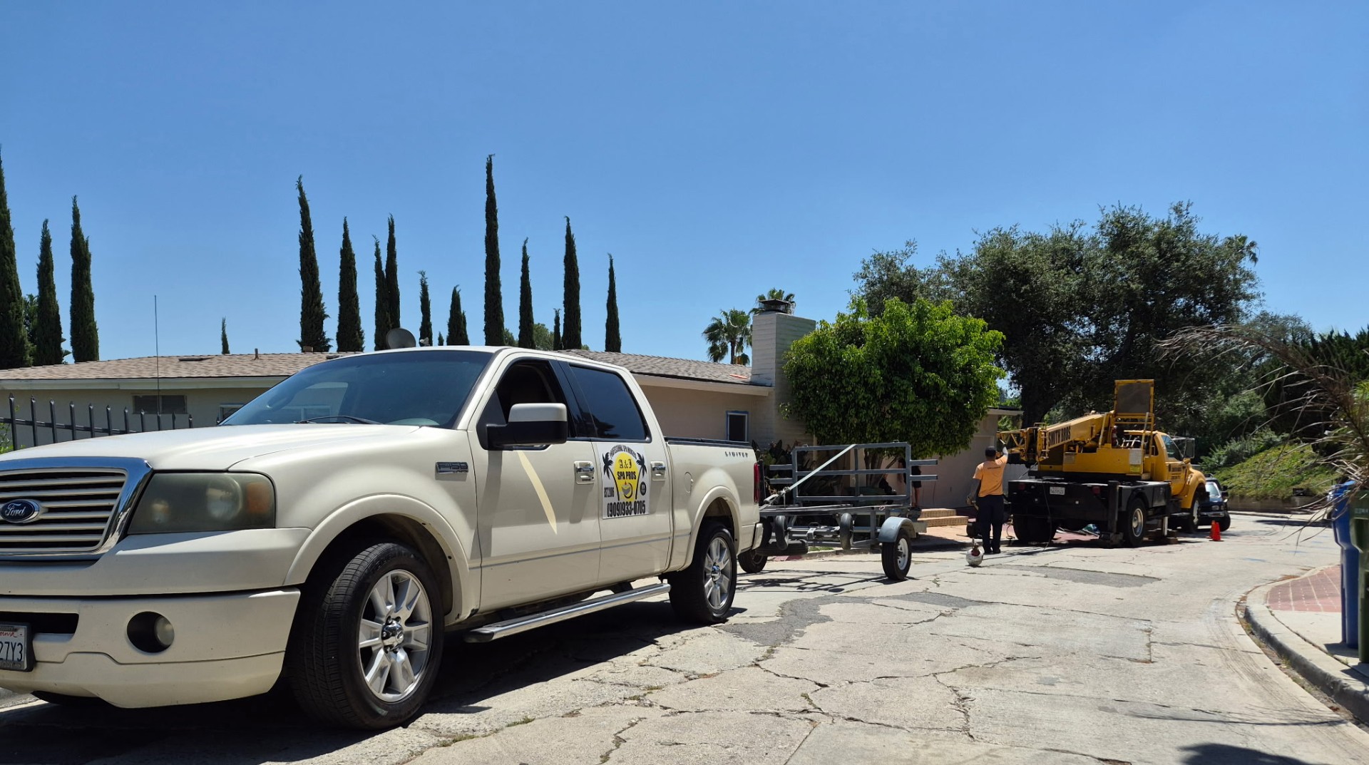 A&J Spa Pros truck and trailer staged on an Altadena street with crane on site for the LA hot tub move