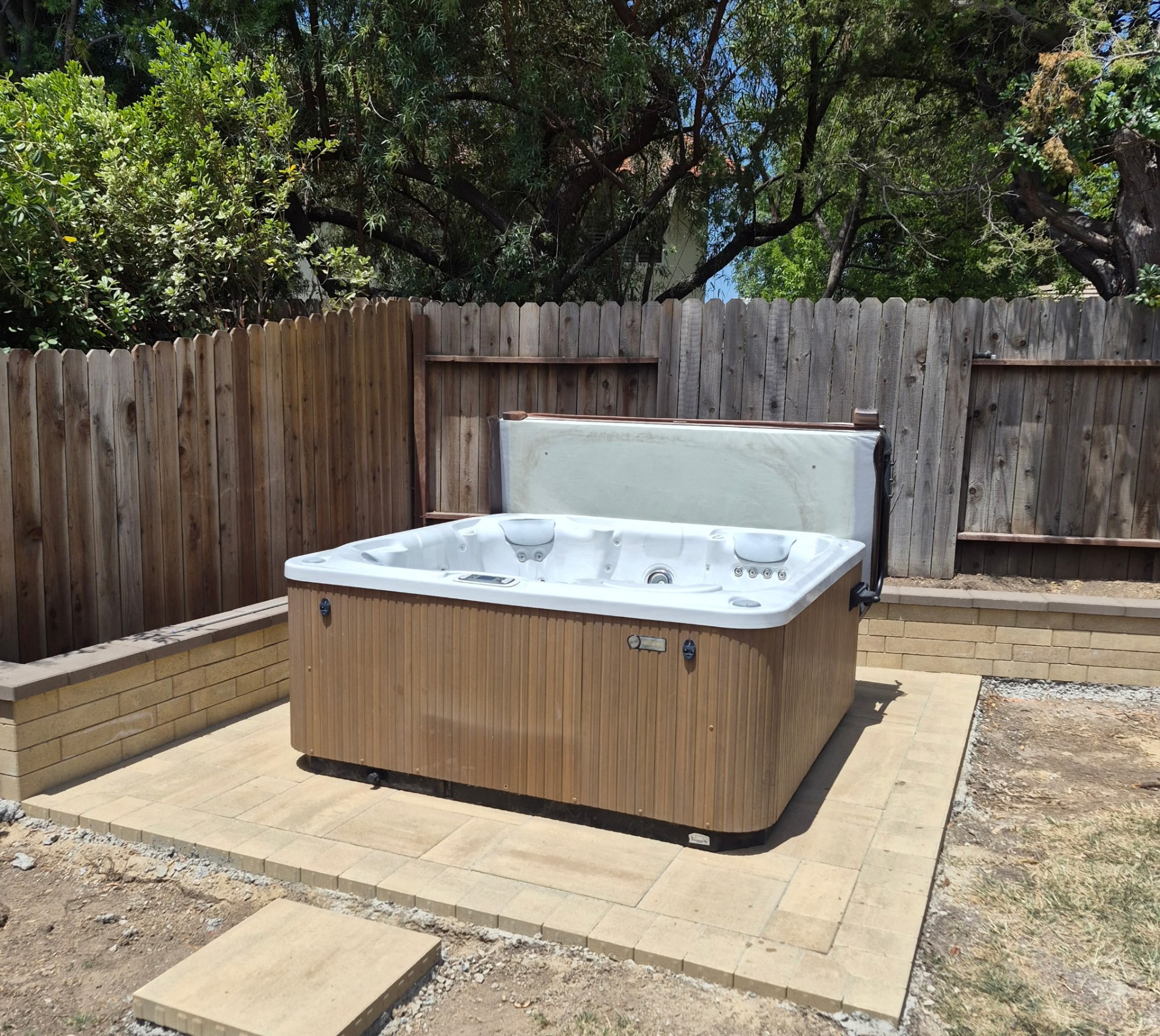 Hot tub installed on a fresh paver patio in a fenced Thousand Oaks backyard